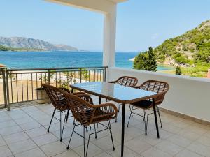 a table and chairs on a balcony with a view of the ocean at Seacret one in Samos