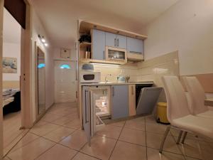 a small kitchen with white cabinets and a counter at Apartments Lavica in Podstrana