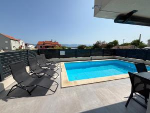 a swimming pool on a patio with chairs and a table at Vila Lana in Nin