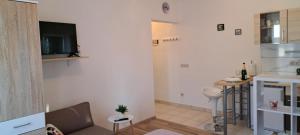 a living room with a couch and a tv on a wall at Studio apartman I&R in Ciovo