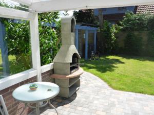 un forno per pizza all'aperto su un patio con tavolo di Behagliches Ferienhaus Mit Garten Und Terrasse a Rerik