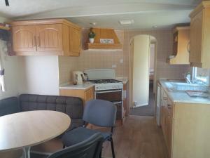 a small kitchen with wooden cabinets and a table with chairs at Domek nad Dunajcem in Gołkowice Dolne +9 photos