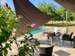 a person sitting in a chair next to a pool at Chambres d'hôtes du Palens in Laugnac