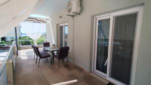 a dining room with a table and chairs and a balcony at ROSE house in Nydri