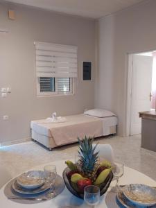 a room with a bed and a table with a bowl of fruit at Sunny house in Kremasti