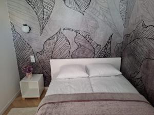 a bedroom with a bed with a mural of leaves at Apartament Pod Malnikiem in Muszyna