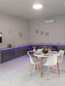 a dining room with a table and white chairs at Sunny house in Kremasti