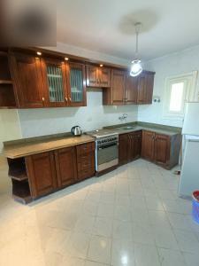 an empty kitchen with wooden cabinets and a stove at شاليه مارينا 6 in El Alamein