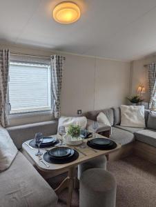 a living room with a table and a couch at Casita De Cuervo at Shorefield Park - WIFI - Pet Friendly - Passes Included in Everton