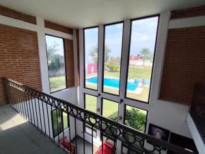 a balcony with windows looking out at a swimming pool at Casa de campo con alberca in Tlayecac