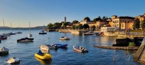 a group of boats in a body of water with buildings at Il Grifo Guest House in Lesa