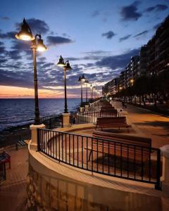 a row of lights on a sidewalk next to the ocean at Cute little Penthouse in the Heart of Sliema in Sliema
