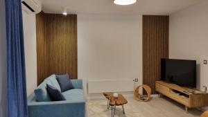 a living room with a blue couch and a tv at EvaMaria apartments in Poreč