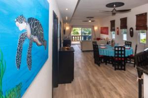 a living room with a dolphin painting on the wall at Pelican Penthouse -Mangrove Dock home in Roatan +38 photos