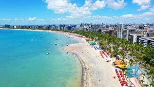 马塞约Casabela 304 | Beira mar de Pajuçara的有遮阳伞和人在水中的海滩