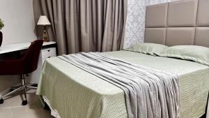 马塞约Casabela 304 | Beira mar de Pajuçara的一间卧室，配有一张床、一张桌子和一把椅子