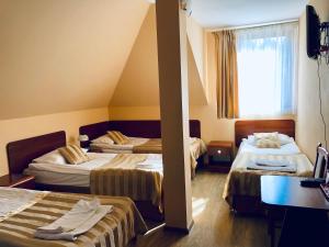 a hotel room with two beds and a window at EMIDA - Restauracja & Hotel in Sinołęka