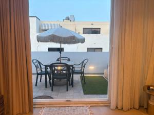 a table and chairs with an umbrella on a balcony at Cute little Penthouse in the Heart of Sliema in Sliema