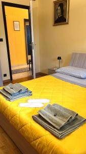 a yellow bed with towels on top of it at Valleverde Apartment in Caraglio