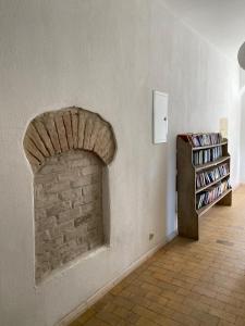 a room with a brick fireplace and a book shelf at Neuensund Manor Entire Inspectors House in Neuensund