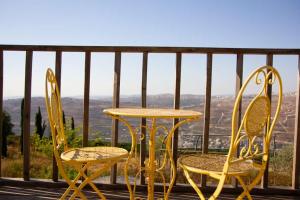 two chairs and a table on a balcony at צימר נוף הארץ יצהר in Mashabbe Sade