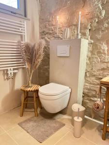 アッシャースレーベンにあるFerienhaus am Markt - ANNO 1708 - App 1の白いトイレと2本のキャンドルがあるバスルーム