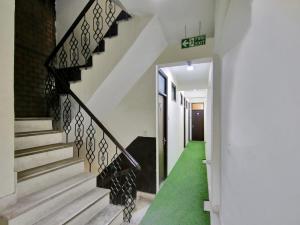 a staircase in a house with a green carpet at Hotel O Darshan Palace in New Delhi