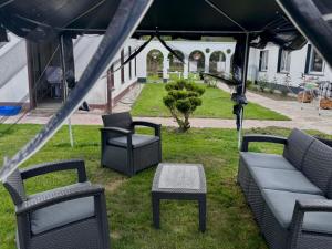 a group of chairs and couches under a tent at Pensjonat Eden Apartament 5 in Borne Sulinowo +8 photos