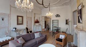 a living room with a couch and a chandelier at Burdigala Homes - Appart Duffour Dubergier in Bordeaux