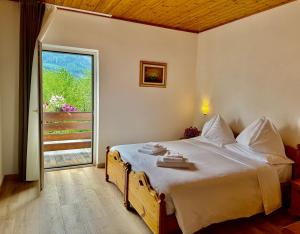 a bedroom with a large bed and a large window at Hotel Latemar in Castello di Fiemme +84 photos