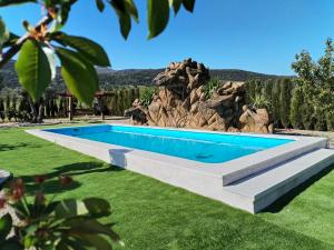a swimming pool in the middle of a grassy yard at Casa rural Cabaña de la Huerta in Navahermosa