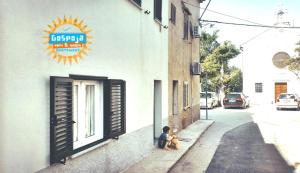 a child sitting next to a building with two teddy bears at Gospoja Park & Beach Apartment Vrbnik in Vrbnik