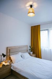 a bedroom with a white bed and a window at Batumi Apartment with Cozy Yard in Batumi