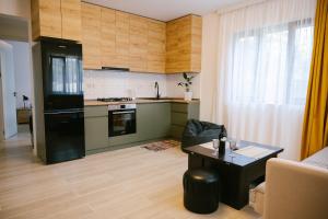 a kitchen with a black refrigerator and a table at Batumi Apartment with Cozy Yard in Batumi