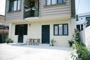 a house with a table and chairs in front of it at Batumi Apartment with Cozy Yard in Batumi