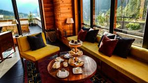 a living room with a couch and a table and chairs at The Postcard Dewa, Thimphu, Bhutan in Thimphu