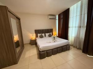 ein Schlafzimmer mit einem großen Bett in einem Zimmer in der Unterkunft El RAYYAN HOTEL SUITES in Amman