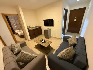 ein Wohnzimmer mit Sofa und Fernseher in der Unterkunft El RAYYAN HOTEL SUITES in Amman