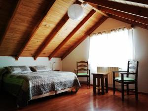 Un dormitorio con una cama y dos sillas. en Nothofagus Bed & Breakfast, en El Chaltén