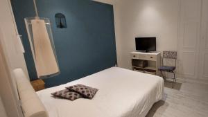 a bedroom with a white bed and a television at Burdigala Homes - Appart Duffour Dubergier in Bordeaux