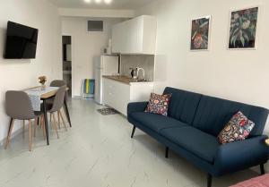 a living room with a blue couch and a kitchen at Vintage in Shëngjin