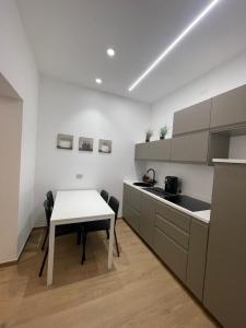 cocina con mesa blanca, mesa y sillas en Cledo mare A - Luxury stay, en Pescara