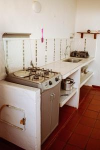 a kitchen with a stove and a sink at Apartahotel Casa de Angel in Villa de Leyva