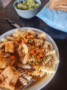 a plate of pasta with meat and vegetables on a table at Vikendica Emily in Kovin