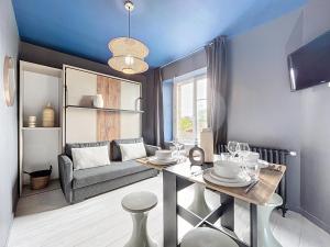 a living room with a table and a couch at Appart Hôtel de la baie in Saint-Jean-le-Thomas