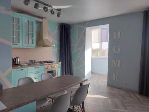 a kitchen with blue cabinets and a table and chairs at Луцеорія студія in Luts'k +7 photos