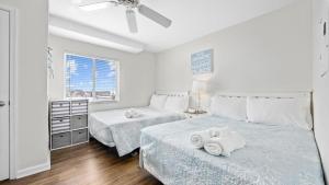 En eller flere senge i et værelse på Steps to Beach - Ocean Views - Pool