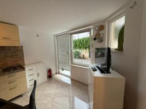 a kitchen with a desk with a computer and a window at Letizia in Banjole