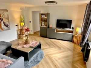 a living room with a couch and a tv at Infinity-Flat Würselen City in Würselen