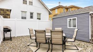 a patio with a table and chairs in front of a fence at Modern Beach Retreat Sleeps 8 - Big Yard & BBQ in Ventnor City